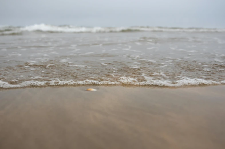 a beach view looking into the water with small waves