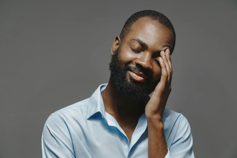 a man with a beard and beard is holding his hands to his face