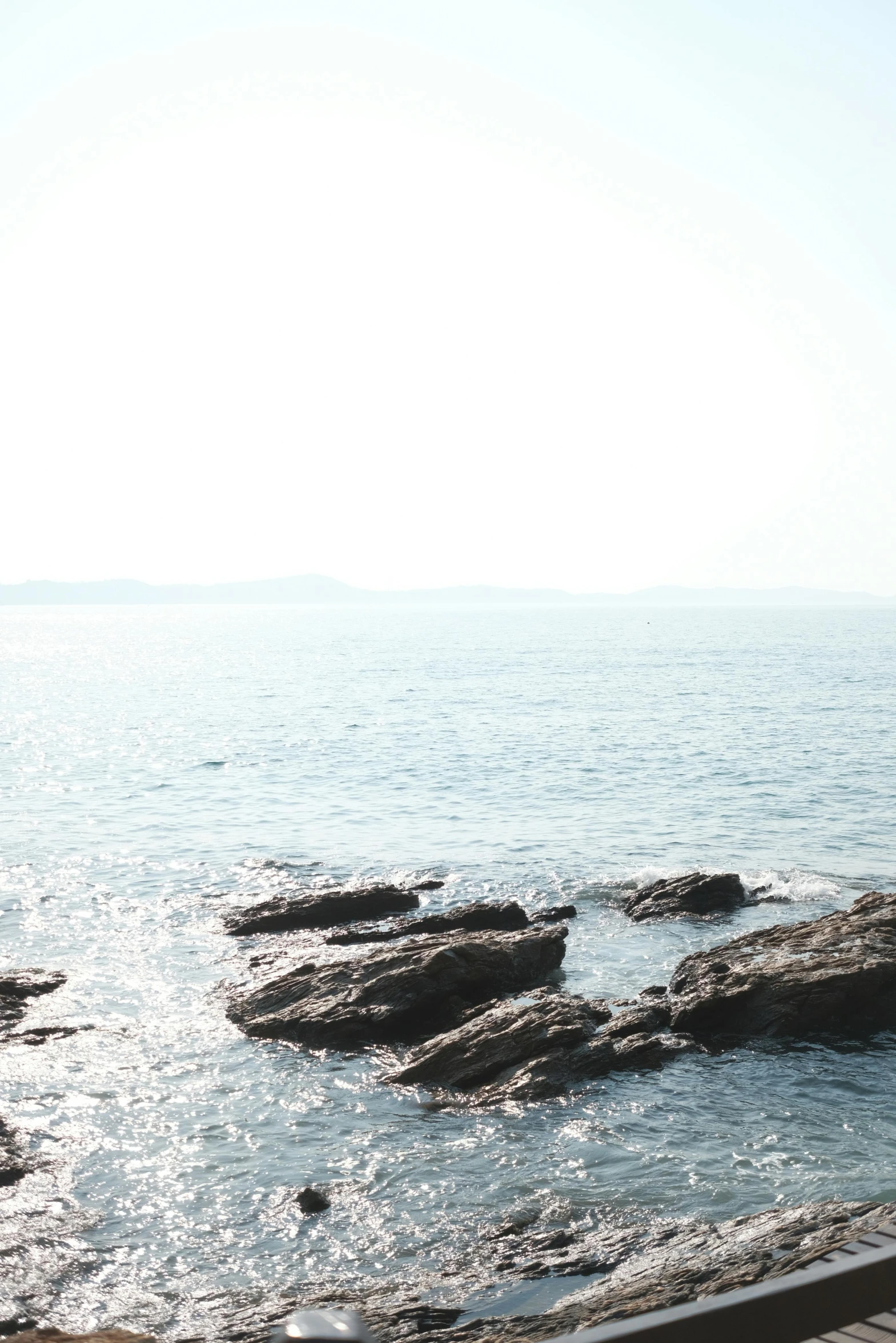 two people on the beach near some rocks