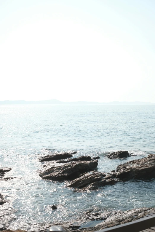 two people on the beach near some rocks