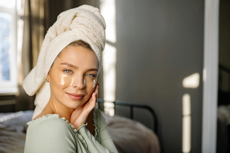 woman with glass of water on her face sitting on her bed