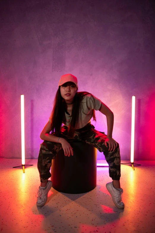 the woman poses on a stool in the room