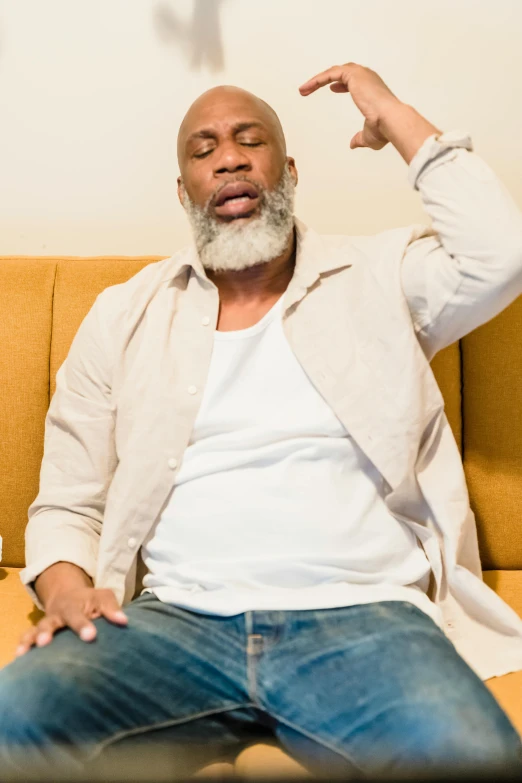 a black man with white beard sitting on a couch