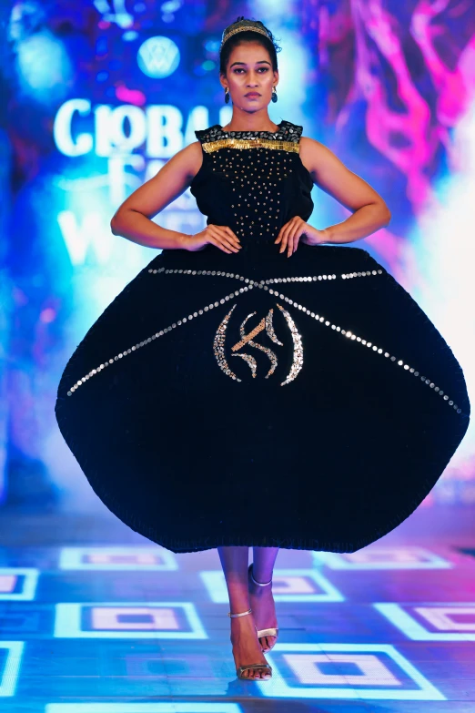 a young model walks down the runway in a black dress