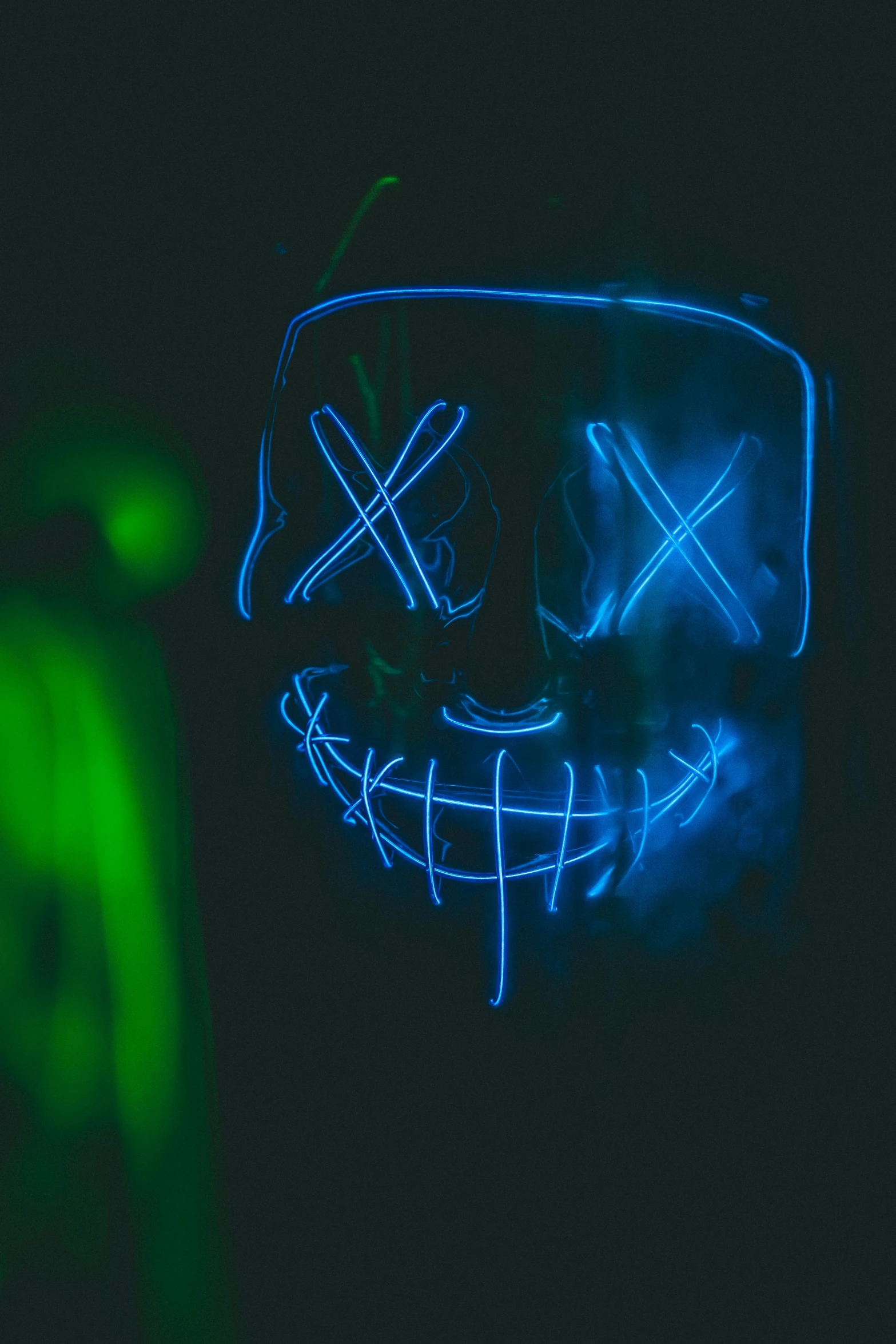 an image of neon light on a half - illuminated face