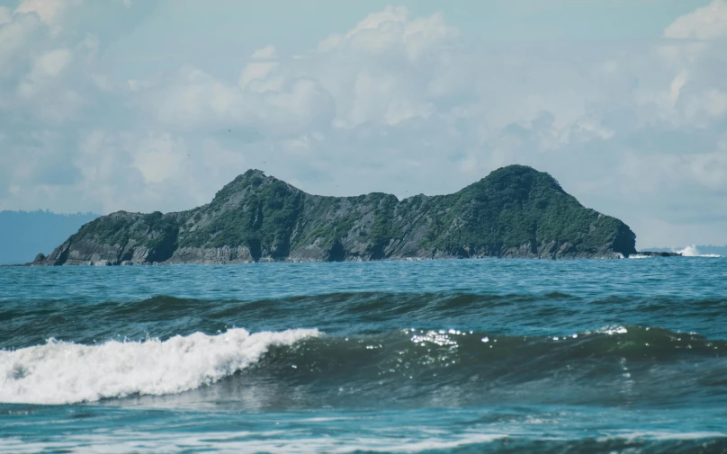 the ocean and rocks on the shore are visible from the waves