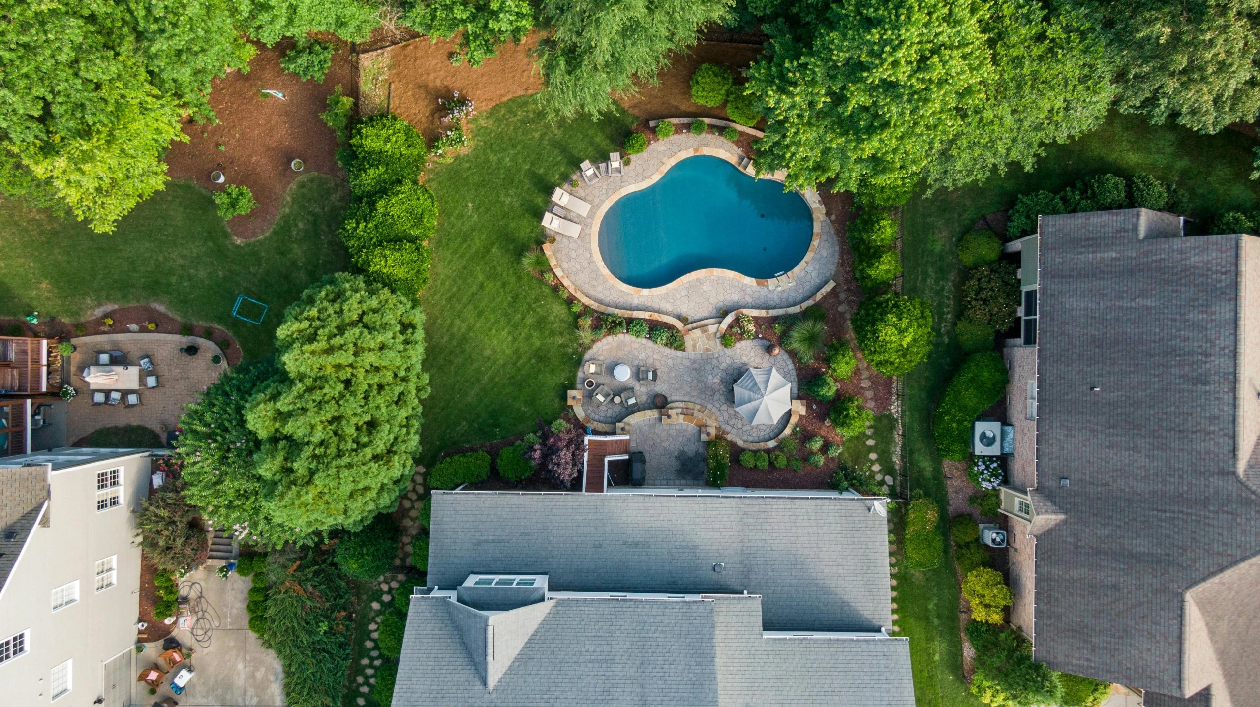 an aerial view of a pool and surrounding homes