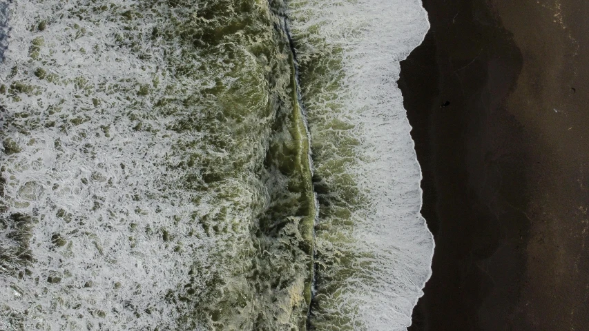 an aerial view of the beach and its wake from waves