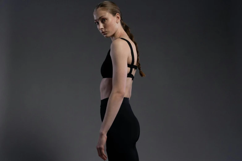 woman in black yoga wear looking back over shoulder