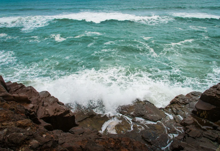 a large body of water with waves crashing on rocks