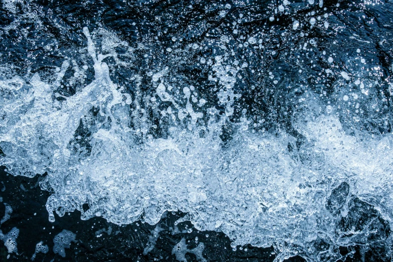 white water splashing off the shore on a blue day