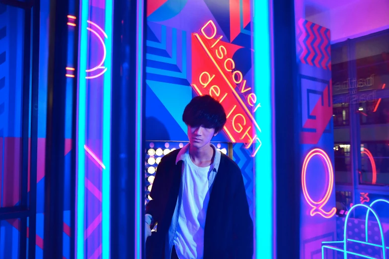 a man standing in front of a building with neon signs on it