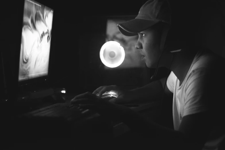 a person with a baseball hat using a computer
