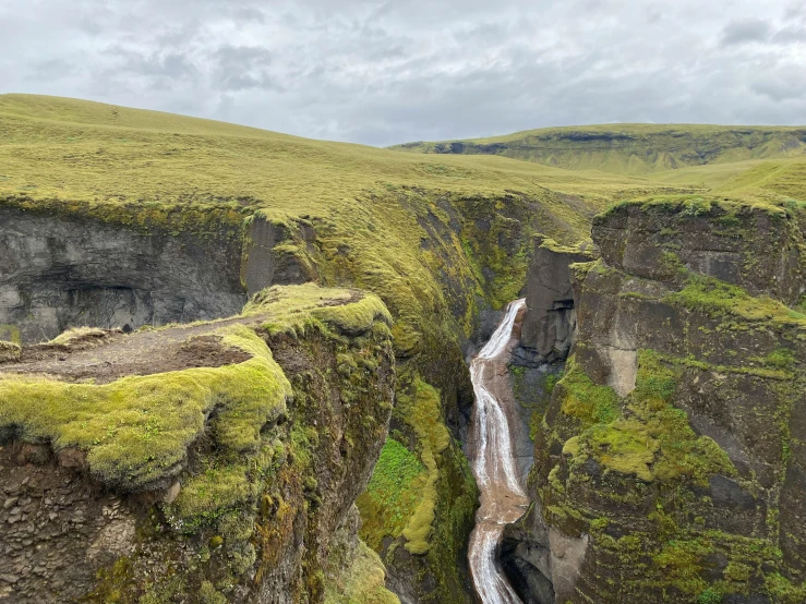 two steep walls with a small waterfall running into the middle