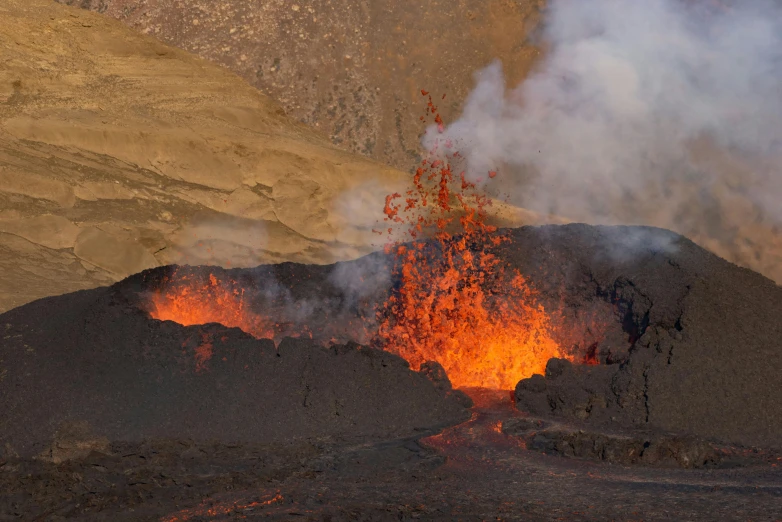 an volcano with lava pouring out and lots of smoke billowing out