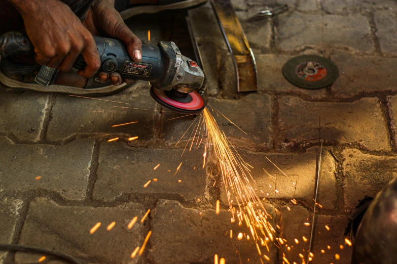 person using grinder on stone floor with metal disc