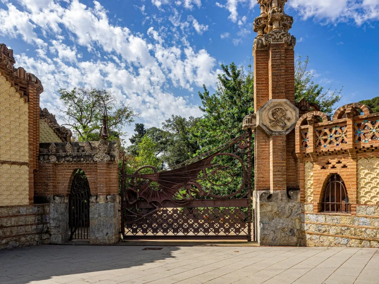 the view of a gated courtyard and tree on the side of a building