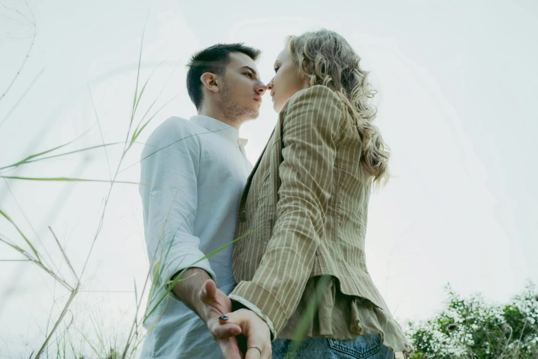 a young man kissing a woman on the cheek