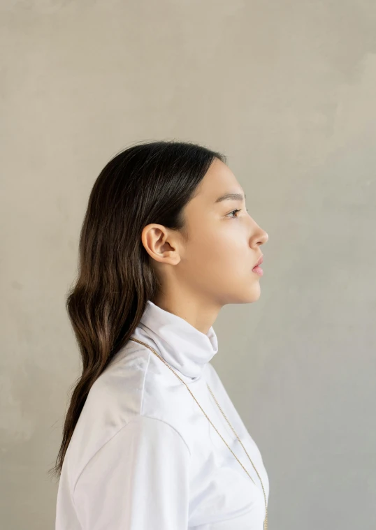 the young woman with ponytails stands and looks away from the camera