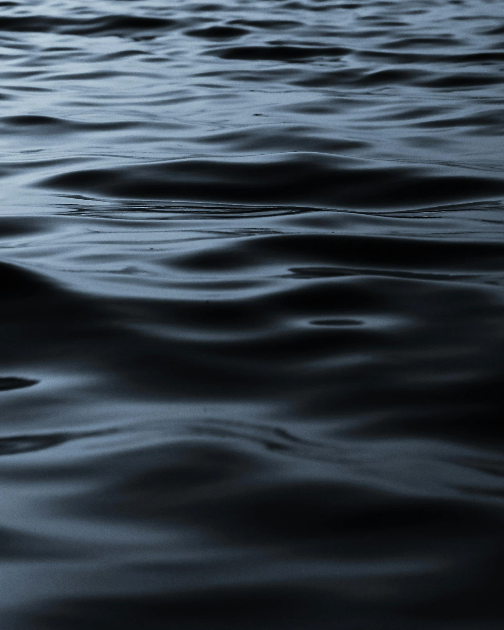 wavy water surface with dark blue colored reflections