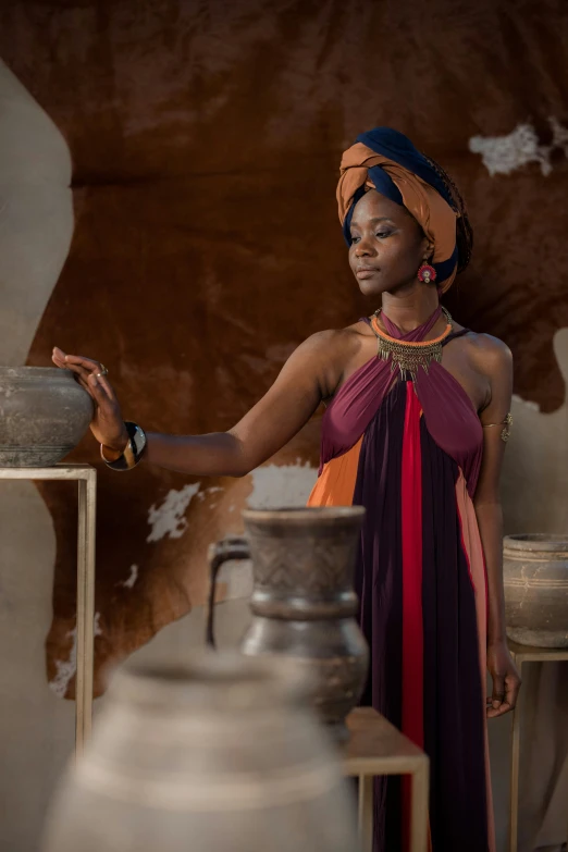 a woman standing near vases and pottery on display