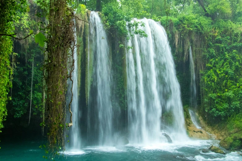 a waterfall in the jungle with clear water