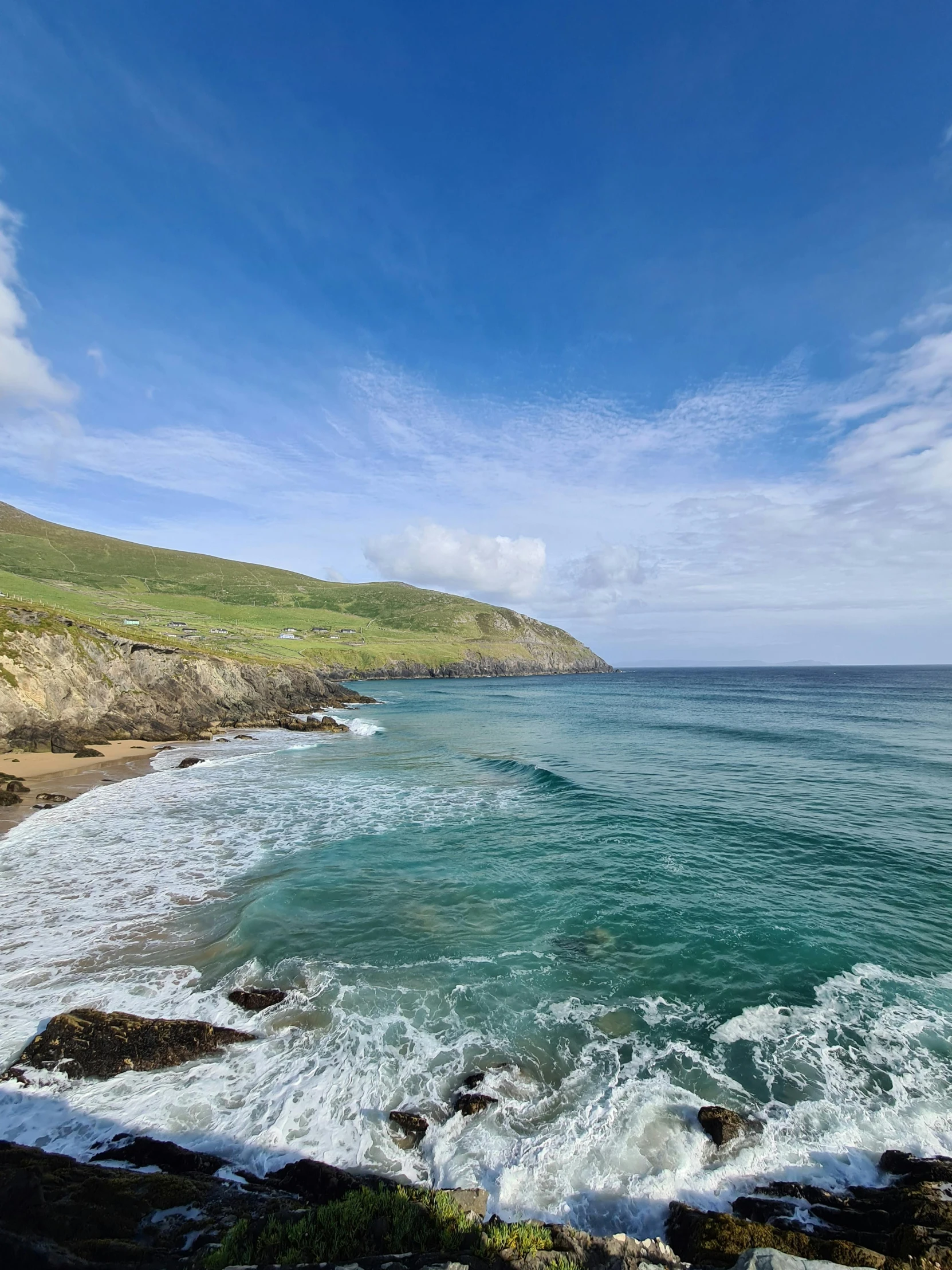 a beach with blue ocean and large wave