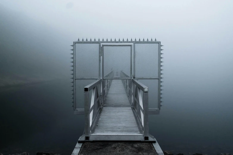 a small path leading to an open door on a foggy day