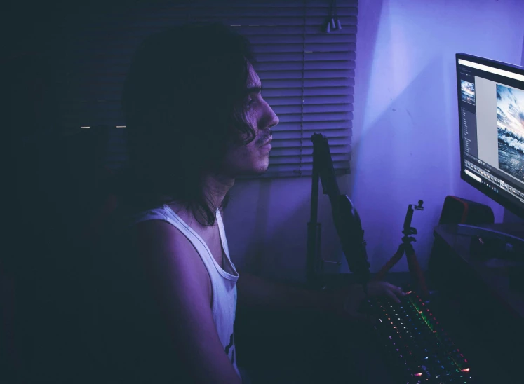 a young lady sitting in front of a computer monitor with the image on screen