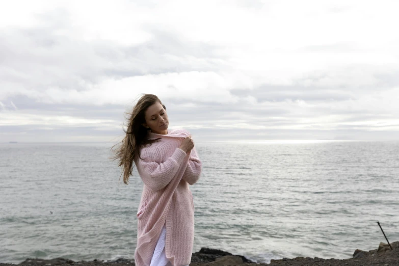 a girl stands at the beach, posing for a po