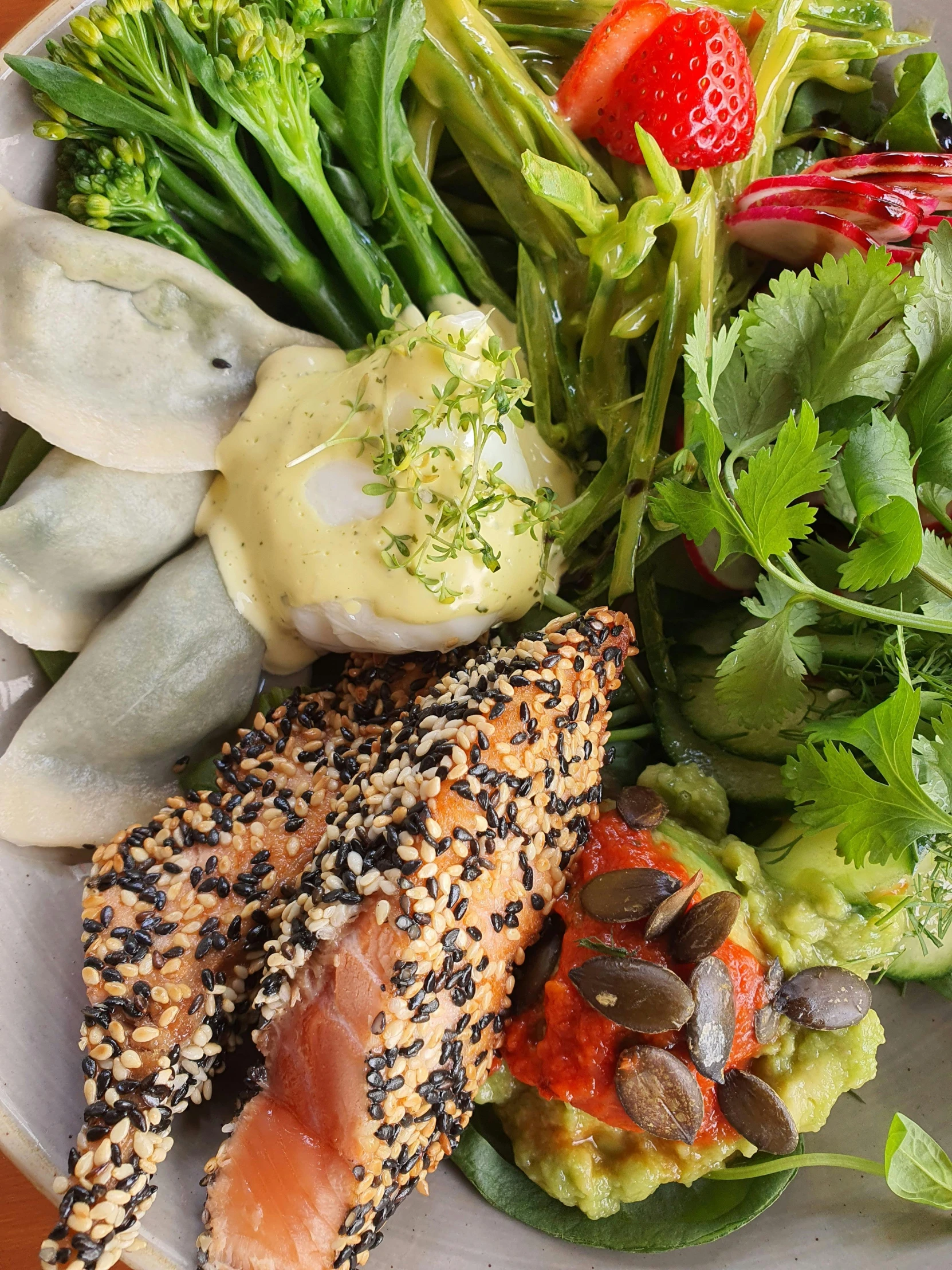 the plate has some vegetables, salad and fish on it