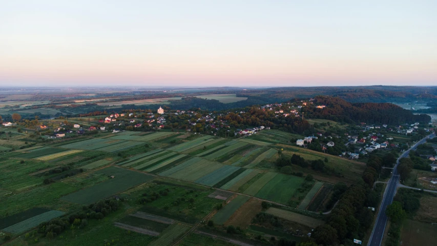 an aerial view of farmland and a town at sunset