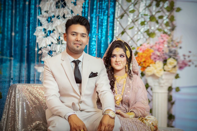 a newly married couple posing in front of flowers