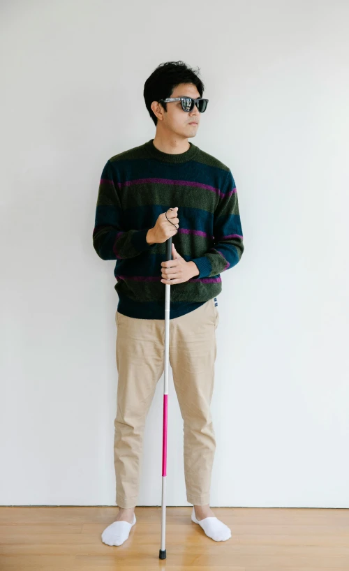 a man stands with his cane in a stance