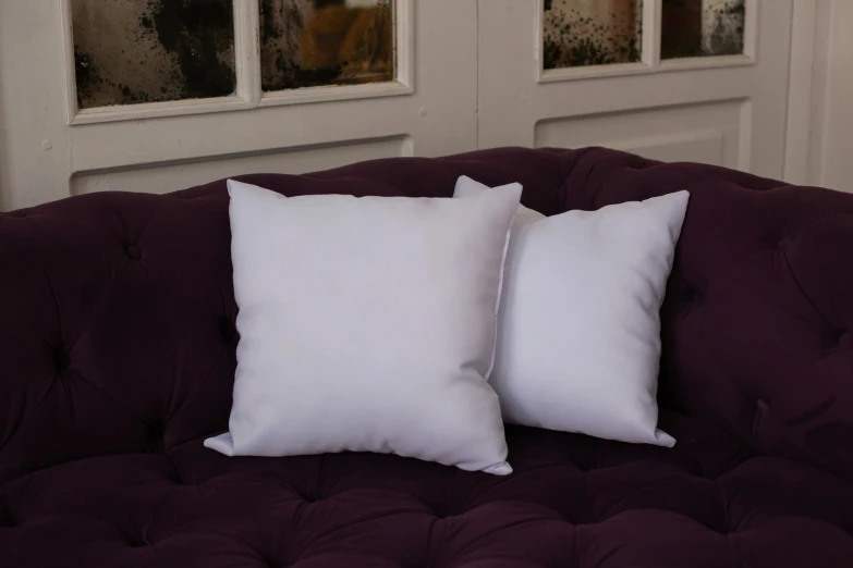 a close up view of two pillows on a couch