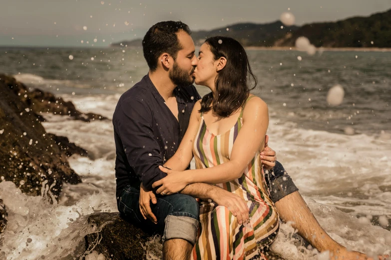 a man kissing a woman on the beach