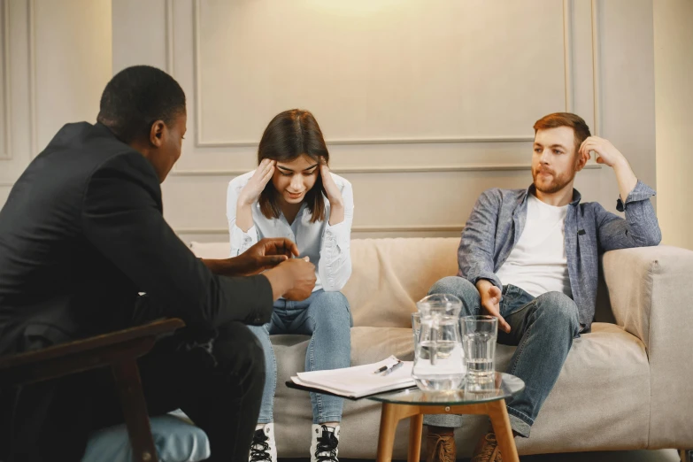 a man and woman are sitting on a couch talking