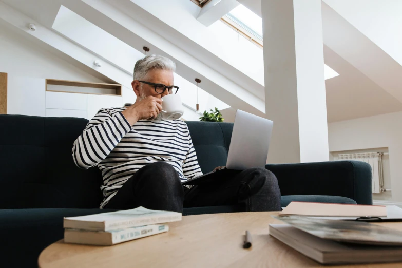 an older man with glasses looking at a laptop