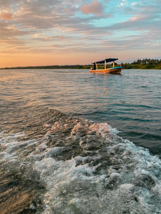 two boats are floating along the shoreline with water spray