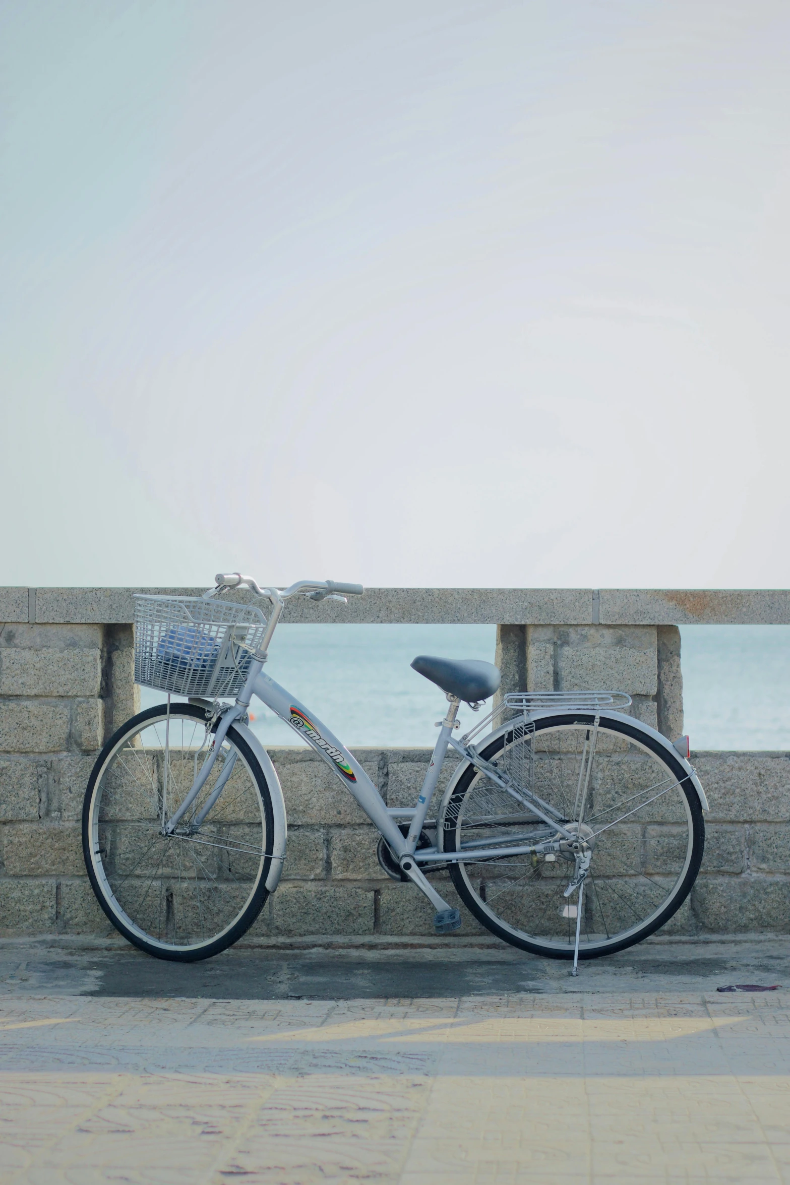 a bike is parked on the sidewalk by the water