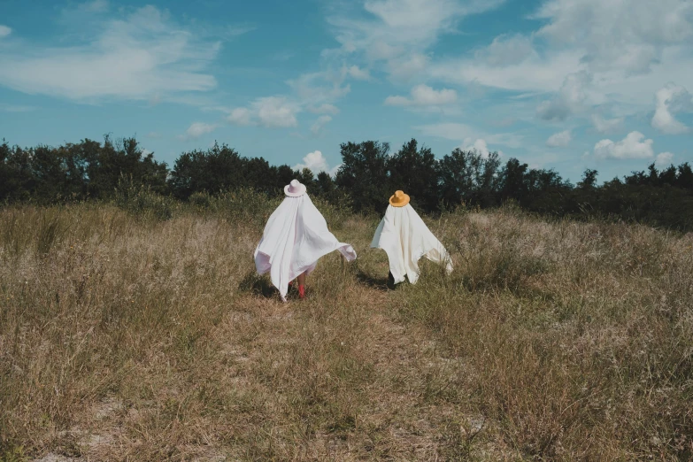 two people are walking in the grass outside