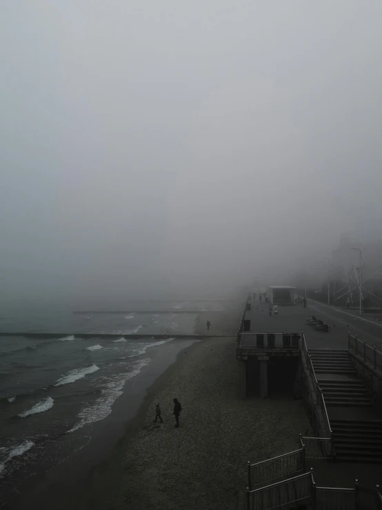 a couple of people walking on a wet beach