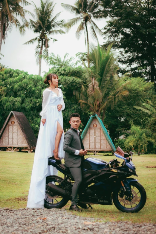 a man and a women standing beside a motorcycle