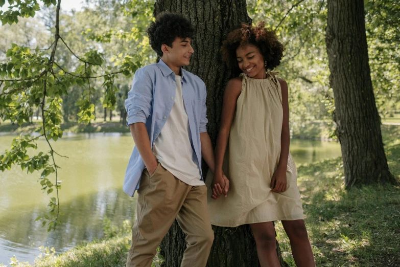 a couple of people standing by a tree