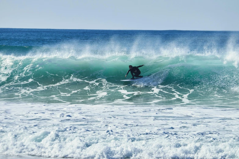 a person is surfing in the waves on a blue ocean