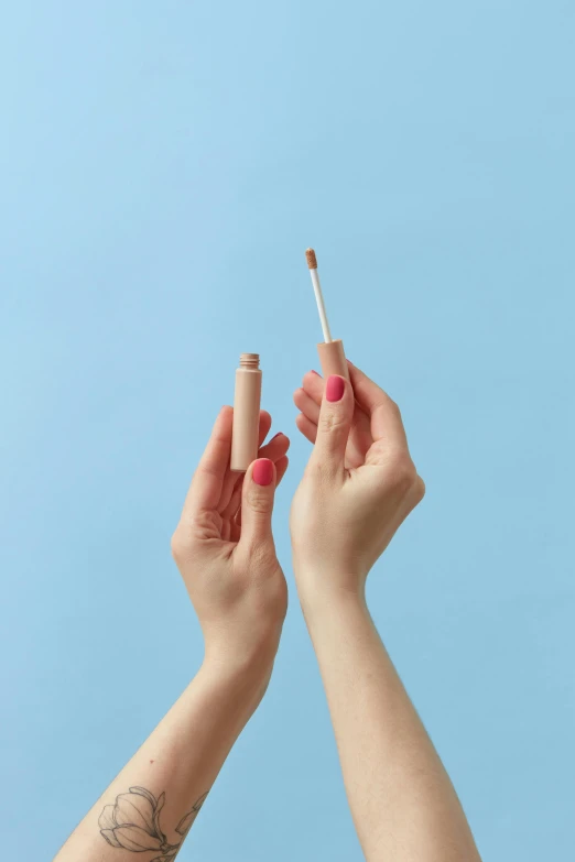 a person holding a cigarette on one arm and another hand with a cigarette in the other