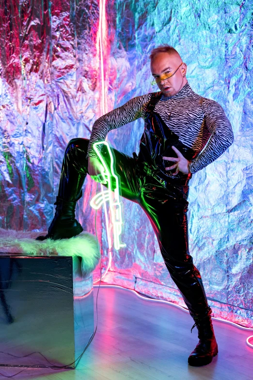 a person wearing shiny clothes and holding a neon light