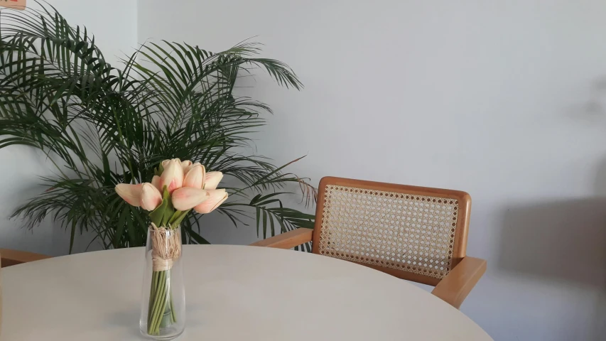 a clear vase with some flowers is on a table