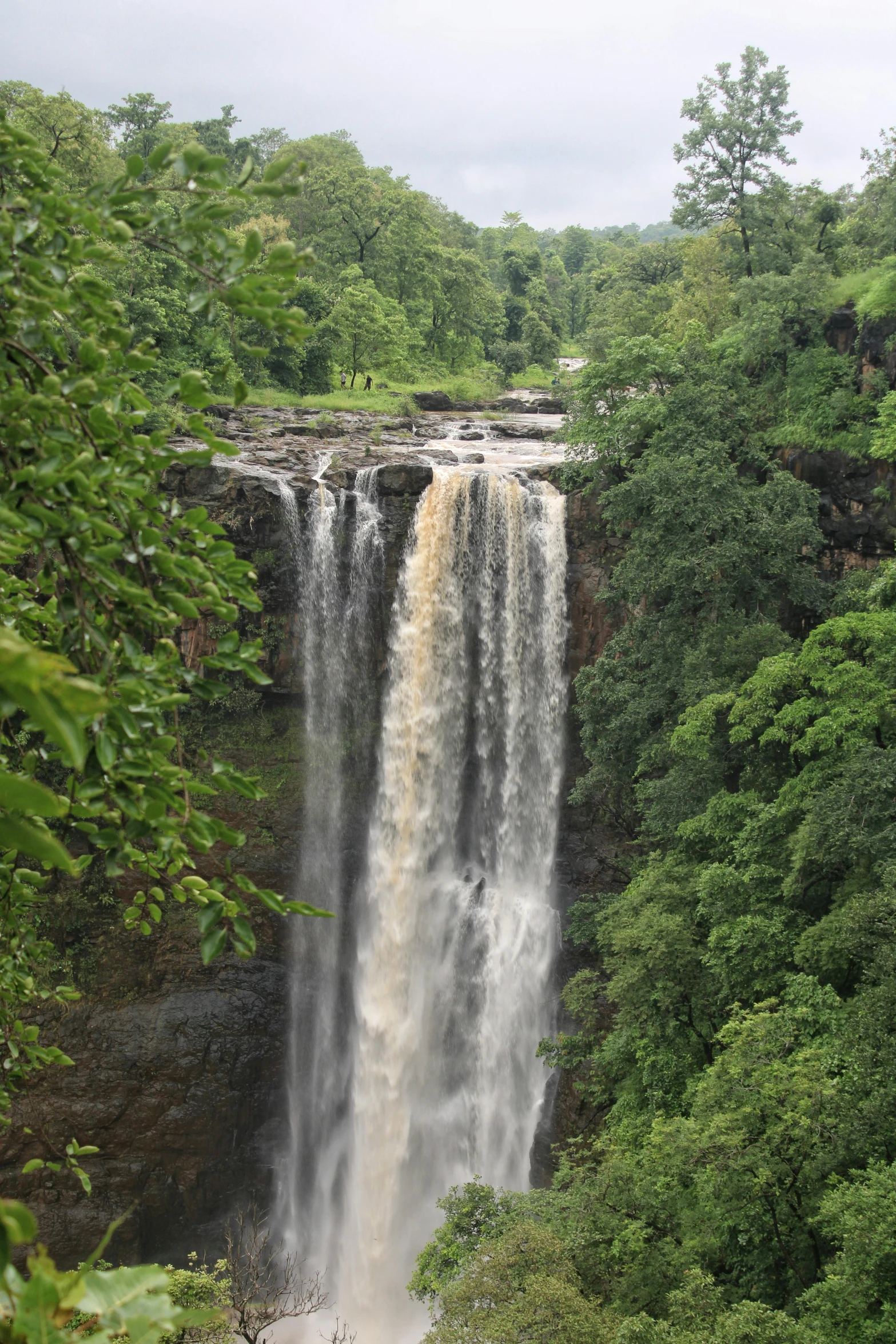 a big waterfall and some people walking in it