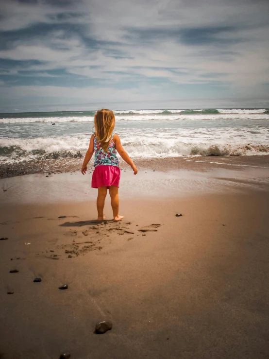 a  is standing on the beach watching the waves